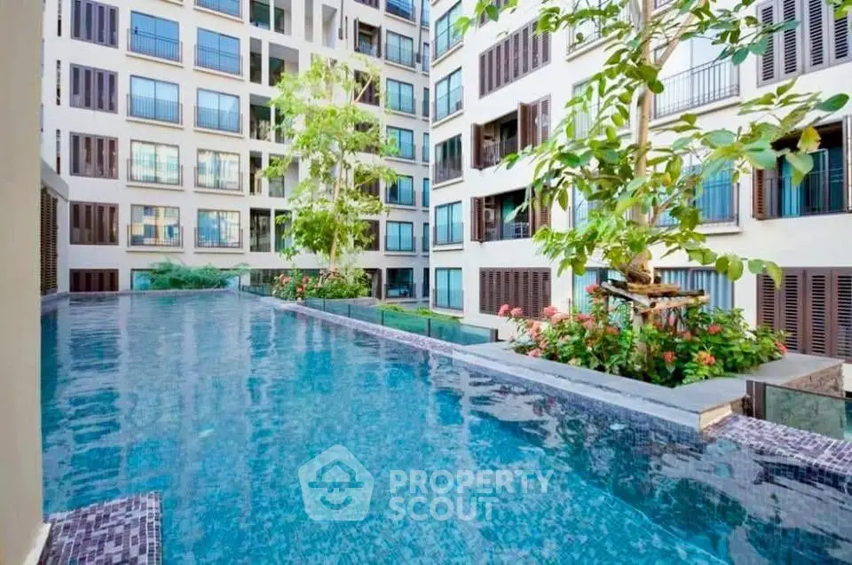 Luxurious apartment complex with stunning pool and lush greenery