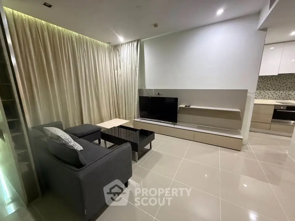 Modern living room with sleek furniture and open kitchen layout in a stylish apartment.
