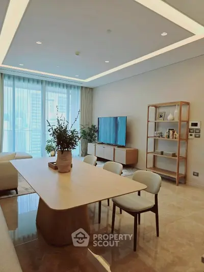 Modern living room with elegant dining table and large TV, featuring floor-to-ceiling windows.