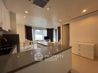 Modern open-layout kitchen and living room with sleek design and ample natural light.