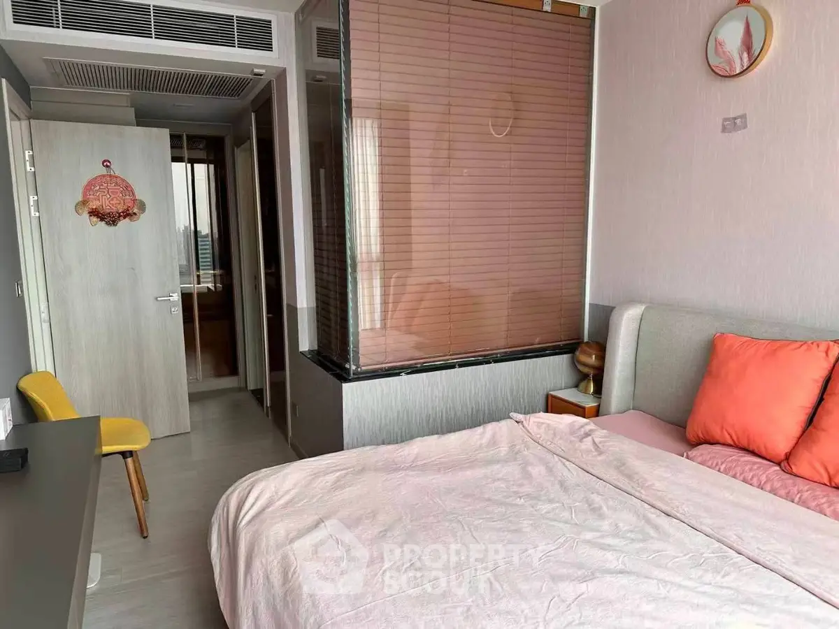 Cozy bedroom with modern decor and large window, perfect for relaxation and comfort.