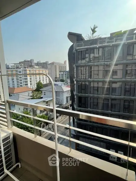 Urban balcony view with modern buildings and clear sky