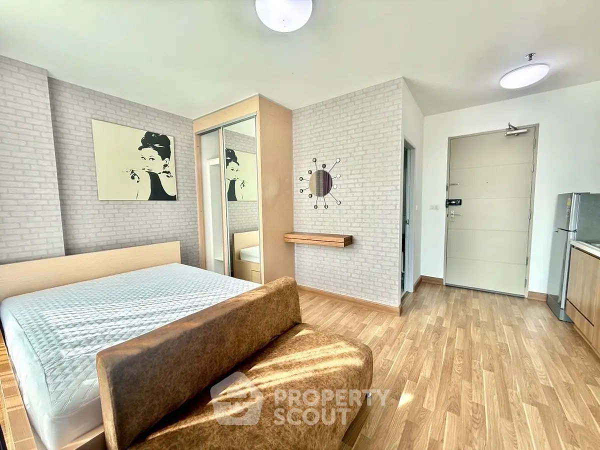 Modern bedroom with stylish decor and wooden flooring in a bright apartment.