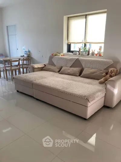 Spacious living room with cozy sofa and dining area, perfect for family gatherings.