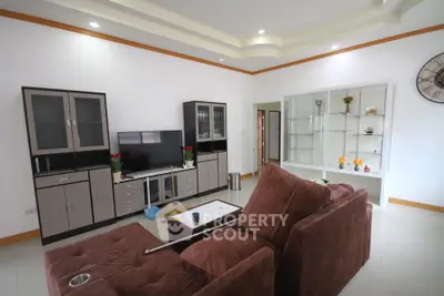 Spacious living room with modern furniture and built-in shelving, perfect for relaxation and entertainment.