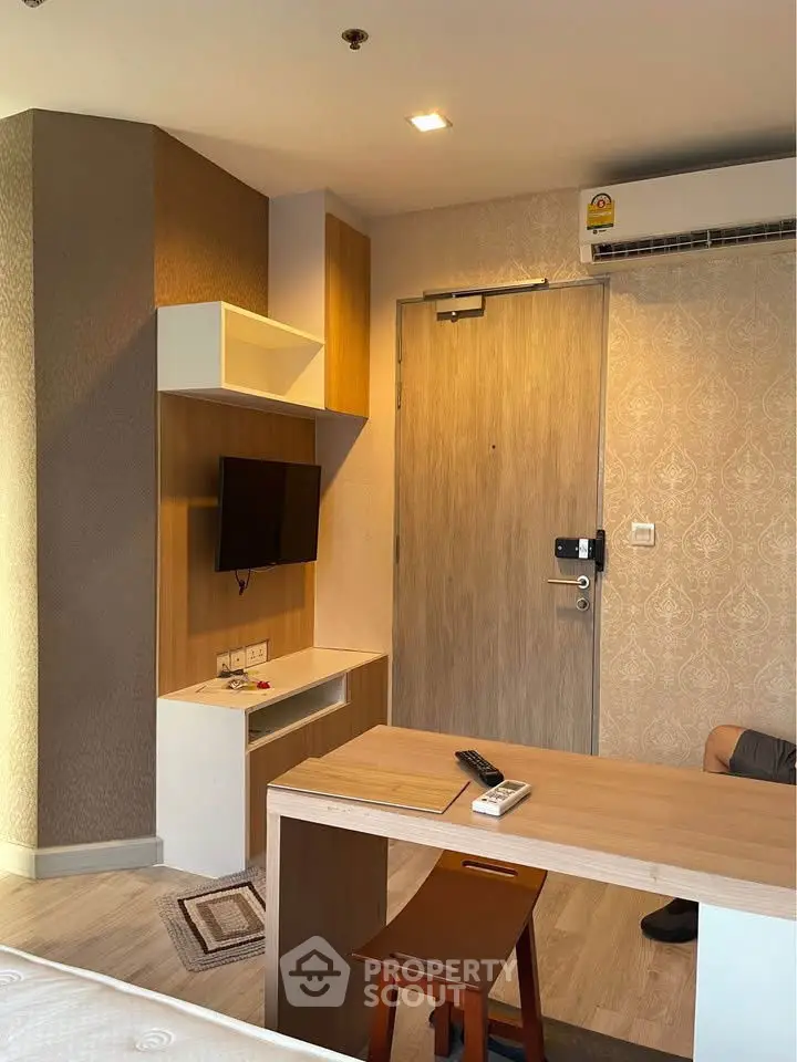 Modern studio apartment interior with stylish furniture and wall-mounted TV, showcasing a cozy living space.