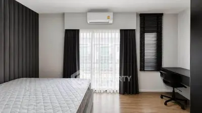 Modern bedroom with sleek design, featuring a comfortable bed, stylish curtains, and a functional study area.