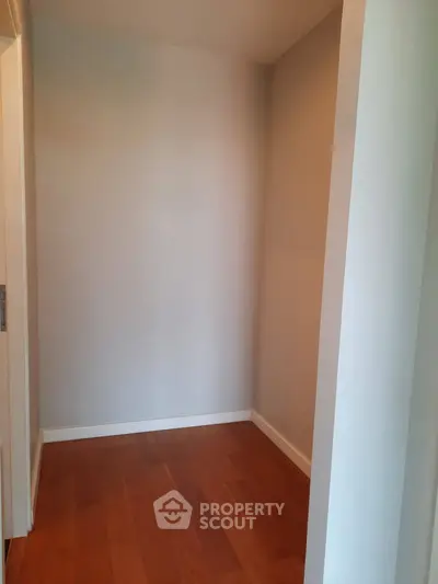 Spacious corner unit with elegant hardwood flooring and neutral wall tones, perfect for customization.