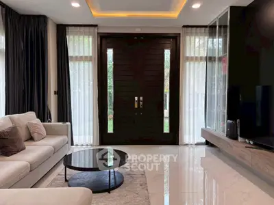 Elegant living room with modern decor and large wooden entrance door