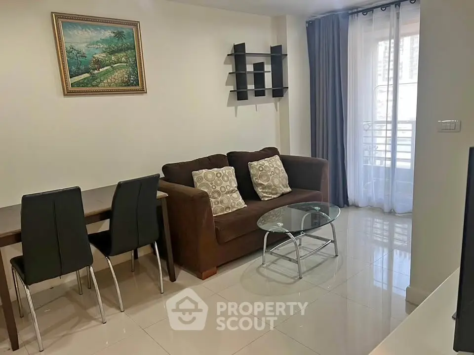 Modern living room with elegant decor, featuring a cozy sofa, glass coffee table, and dining area.