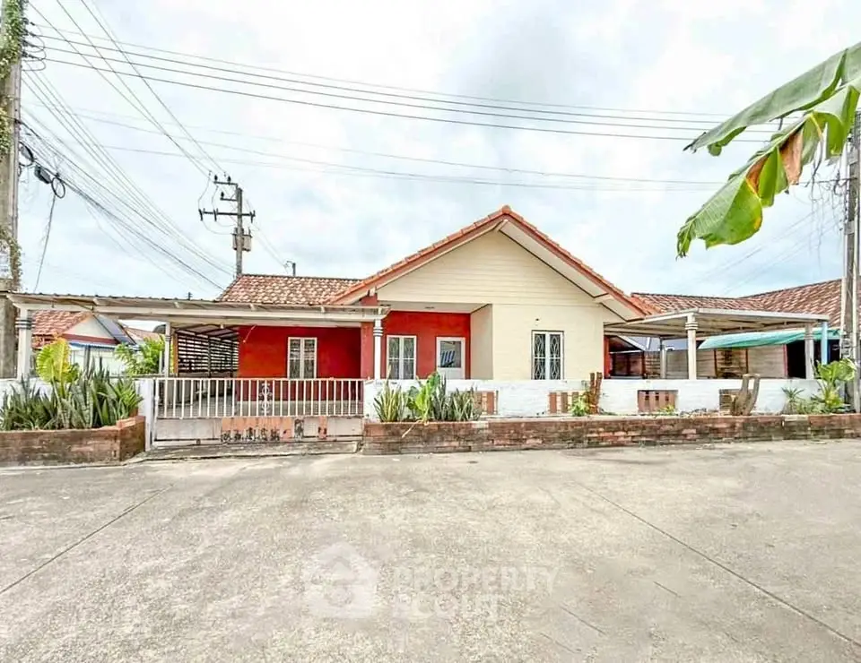Charming single-story house with red brick facade and spacious driveway.