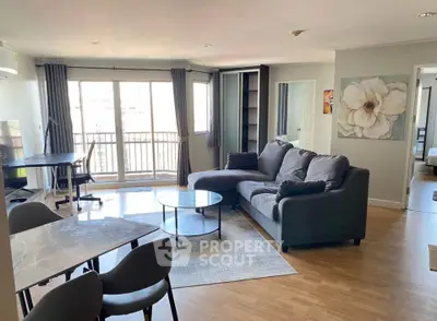 Spacious living room with modern decor and large windows in a stylish apartment.