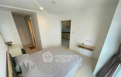 Cozy bedroom with modern decor and view into kitchen area