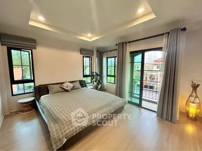 Spacious bedroom with large windows and balcony access in modern home