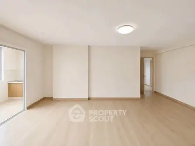 Spacious empty living room with wooden flooring and natural light
