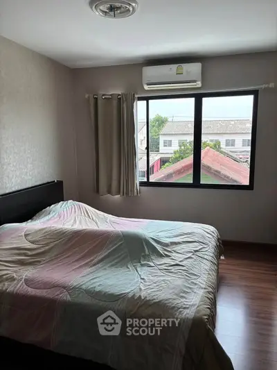 Cozy bedroom with large window and air conditioning, perfect for relaxation.
