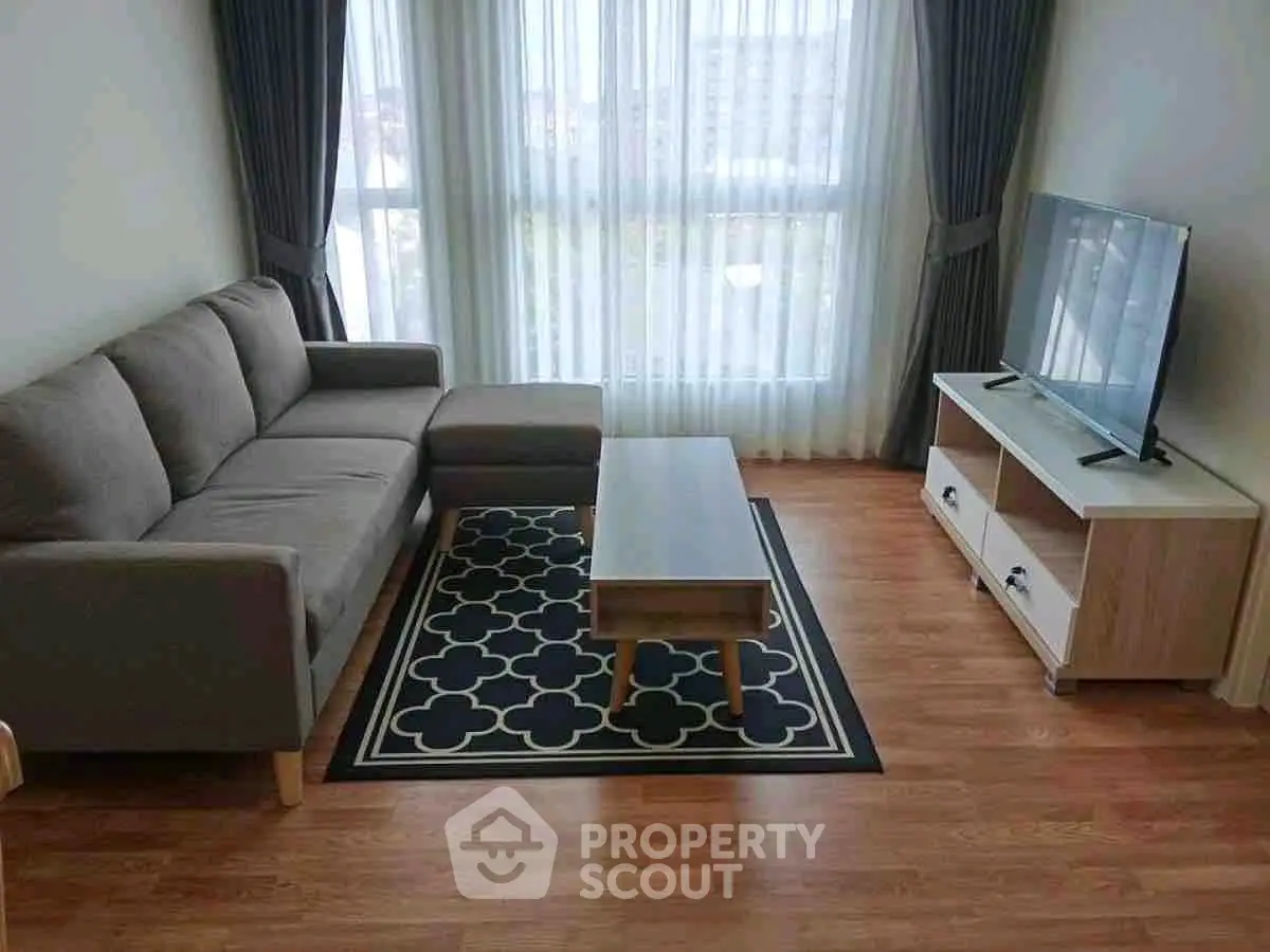 Modern living room with stylish sofa, TV unit, and large window for natural light.