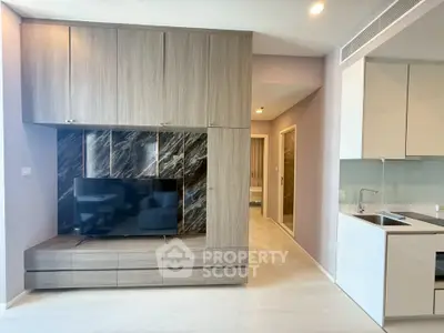 Modern living room with built-in TV unit and sleek kitchen design