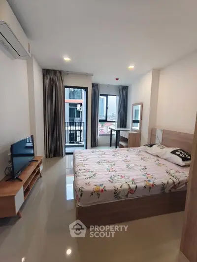 Modern bedroom with balcony view, featuring stylish furniture and natural light.