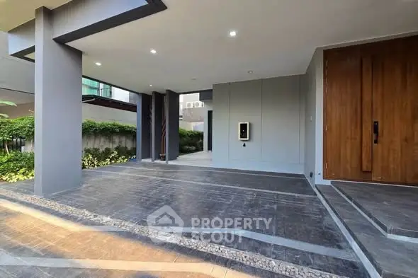 Modern building entrance with sleek design and lush greenery
