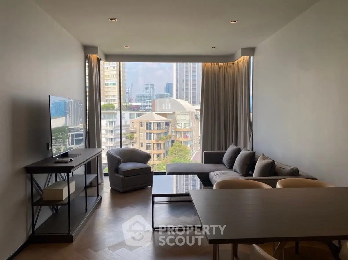 Modern living room with city view, stylish furniture, and large windows.