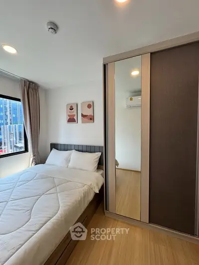 Cozy bedroom with modern decor and ample natural light, featuring a comfortable bed and stylish wardrobe.
