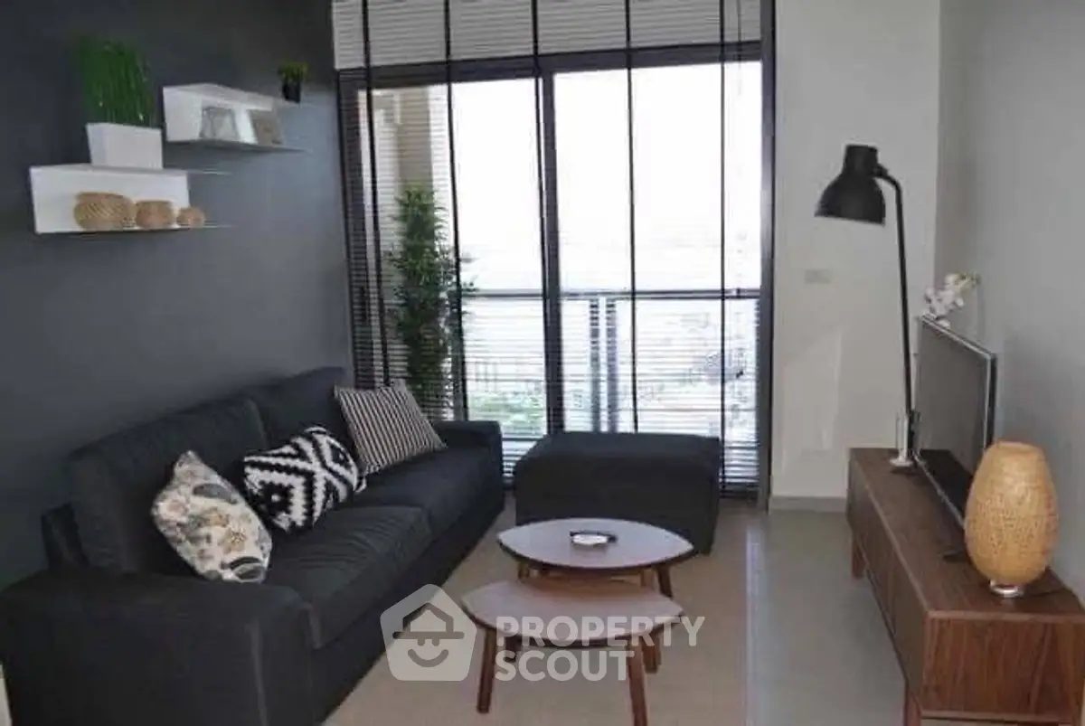 Modern living room with stylish decor and large windows offering natural light.