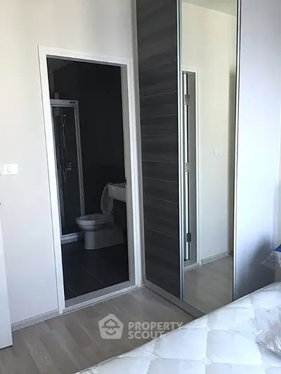 Modern bedroom with ensuite bathroom and mirrored closet doors
