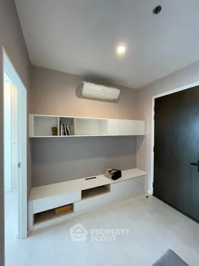 Modern minimalist interior with built-in storage and air conditioning in a cozy living space.