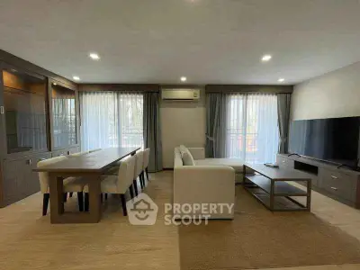 Spacious modern living room with elegant dining area and large windows for natural light.