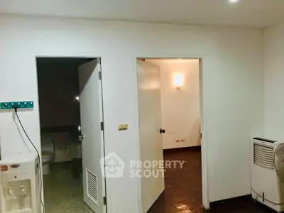 Cozy interior space with white walls, doors, and a water dispenser, ideal for versatile use.