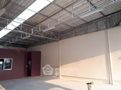 Spacious industrial warehouse with high ceilings and ample natural light.