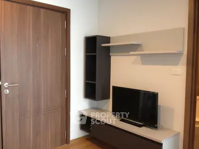 Modern living room with sleek TV unit and wooden door, perfect for cozy urban living.