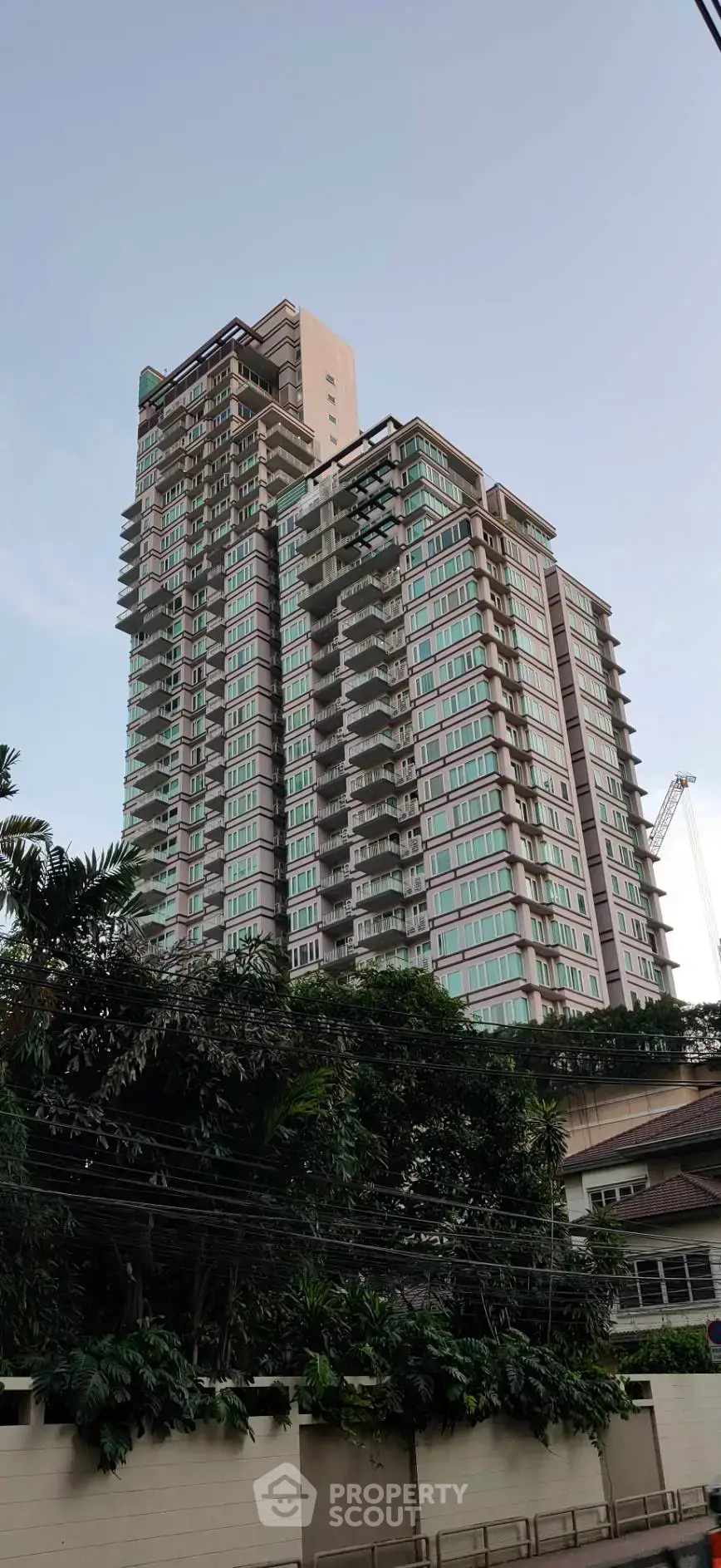 Stunning high-rise building with modern architecture and lush greenery, perfect for urban living.
