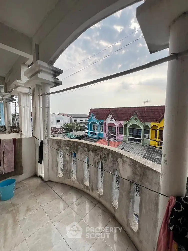 Charming balcony with view of colorful houses, perfect for relaxing and enjoying the neighborhood.