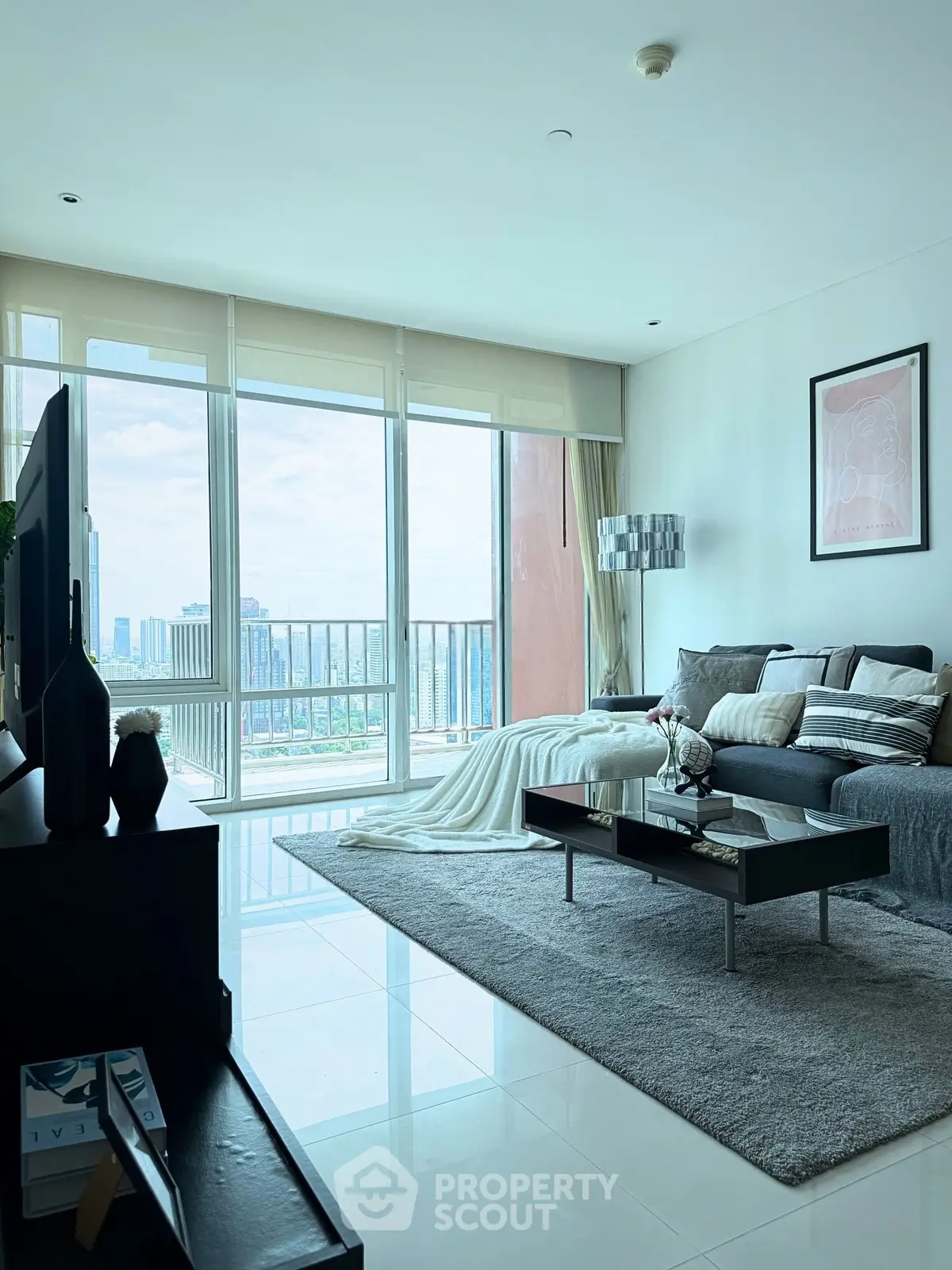 Modern living room with large windows and city view, featuring stylish furniture and decor.