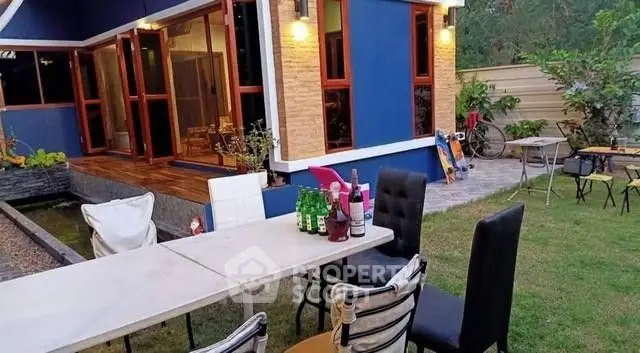 Charming backyard with modern patio furniture and vibrant blue house exterior.
