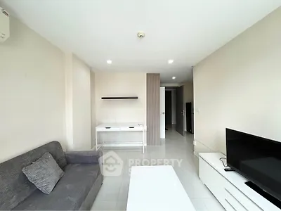 Spacious living room with modern furniture and natural light, perfect for relaxation and entertainment.