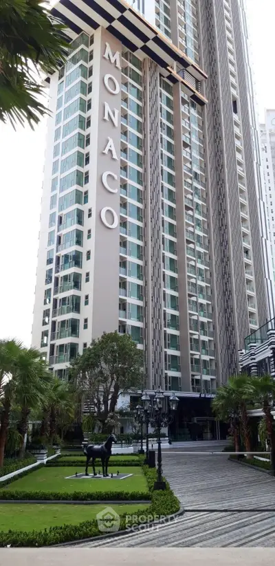 Luxurious high-rise building with elegant entrance and lush landscaping in prime location.
