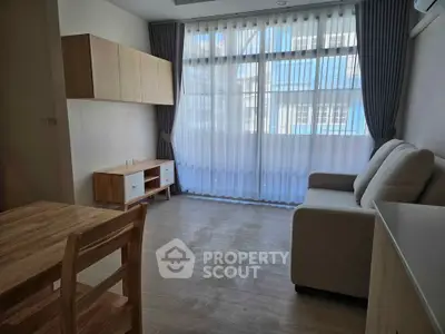 Bright living room with modern furniture and large windows in a stylish apartment.