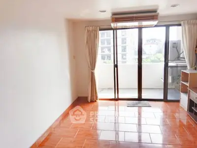 Spacious living room with large windows and wooden flooring, perfect for natural light lovers.