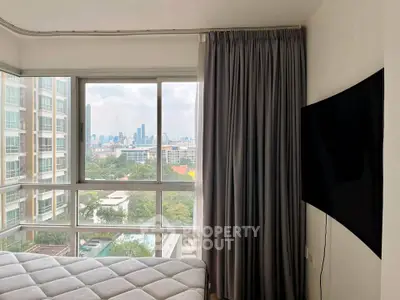 Modern bedroom with large windows offering stunning city view and natural light.