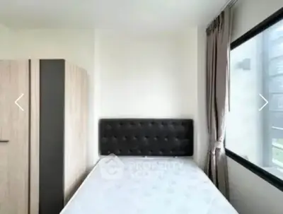 Cozy bedroom with large window and modern furnishings in a bright apartment