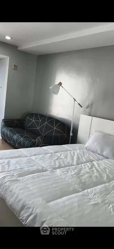 Modern bedroom with stylish sofa and cozy lighting, perfect for relaxation and comfort.