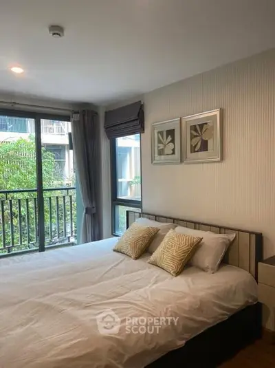 Cozy bedroom with large window and stylish decor in modern apartment