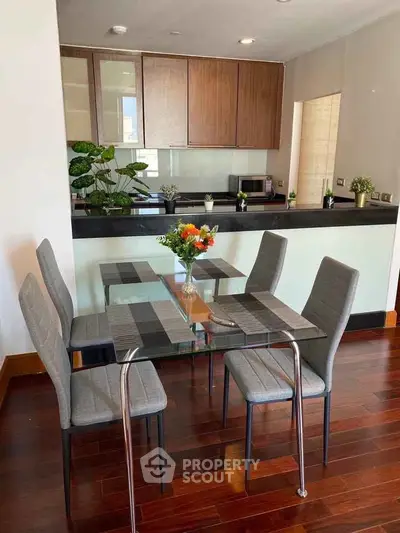 Modern dining area with glass table and stylish chairs in open kitchen layout