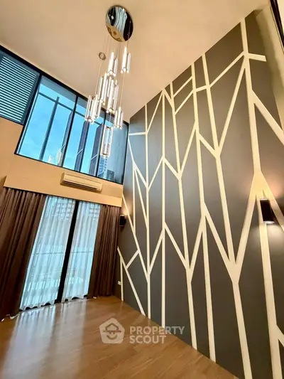 Stunning modern living room with high ceilings and unique geometric wall design