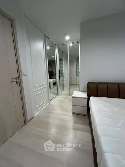 Modern bedroom with mirrored closet doors and minimalist design