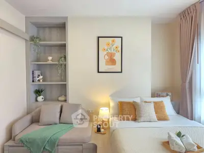Cozy bedroom with stylish decor and natural light, featuring a comfortable bed and a small sofa.