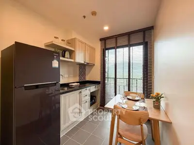 Modern kitchen with dining area and natural light from large window.
